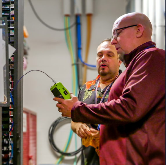 Two network engineers diagnosing issue with a fiber line